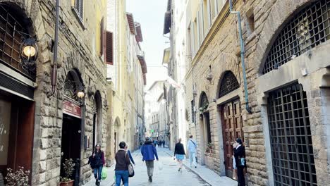 POV-of-people-walking-through-the-stone-and-ancient-streets-of-Florence,-Italy-on-a-sunny-and-clear-day
