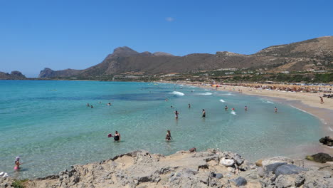 Gente-Bañándose-Y-Relajándose-En-La-Exótica-Playa-De-Falasarna-En-Verano-En-Creta,-Grecia