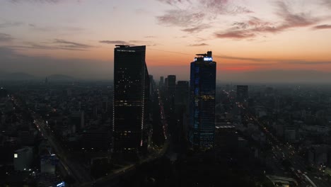 Aerial-view-around-skyscrapers-at-the-Reforma-avenue,-dramatic-dusk-in-Mexico-city