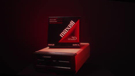 Maxell-floppy-pack-disks-on-top-of-a-floppy-drive,-4K,-moving-shot