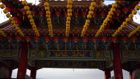 Tilt-down-view-of-the-beautiful-yellow-lanterns-celebrating-Mazu's-Birthday-and-overlooking-the-cityscape-skyline-in-Thean-Hou-Temple,-Kuala-Lumpur,-Malaysia