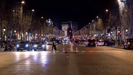 Busy-intersection-after-dark-in-Paris,-France