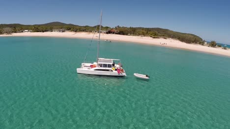 Track-around-catamaran-on-beautiful-green-water-next-to-beach,-the-great-Barrier-Reef
