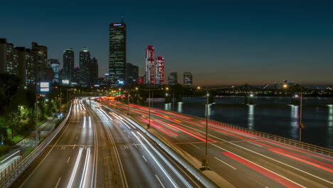 Night-scenery-of-cars-moving-fast-in-downtown-district-around-Olympic-Expressway-and-63-Building-in-Yeouido-Nearby-Han-River-Gangnam-gu-and-Yeongdeungpo-gu,-Seoul,-South-Korea---high-angle-panoramic