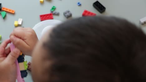 Slow-motion-shot-of-a-young-child-playing-with-and-building-items-with-building-block