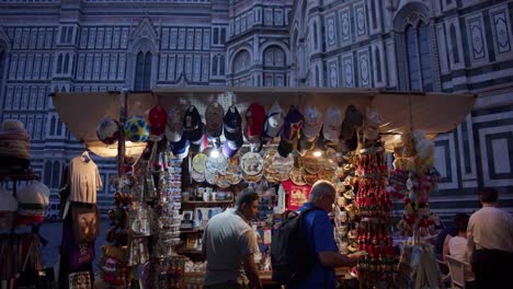 Touristischer-Souvenir-Straßenhändlerstand-In-Florenz,-Italien,-Der-Schmuckstücke-Mit-Der-Kathedrale-Von-Florenz-Im-Hintergrund-Verkauft