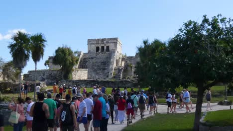 Tourists-visiting-The-Castle-mayan-ruins-in-sunny-day-at-Tulum-archeological-site,-Quintana-Roo,-Mexico