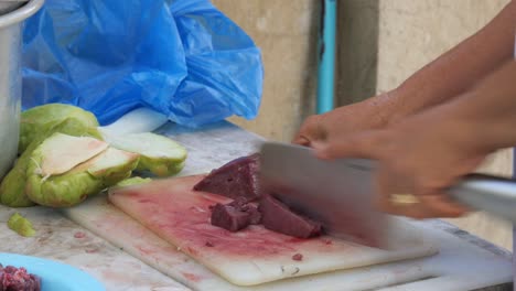 April,-22-2023,-Danao-City,-Cebu,-Philippines---Woman-Cutting-Pork-Liver-on-a-Kitchen-Board-Preparing-Ingredients-for-a-Traditional-Filipino-Dish