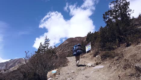 Gehaufnahme-Eines-Nepalesischen-Sherpas,-Der-Langsam-Durch-Die-Berge-Des-Himalaya-Geht-Und-Eine-Riesige-Und-Schwere-Tasche-Annapurna-Nepal-Trägt