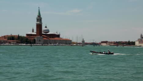 Panoramic-view-of-the-Venetian-lagoon-and-city,-with-boats-passing-by-in-Venice,-Italy