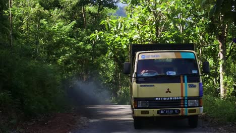 A-Mitsubishi-truck-climbs-a-road-up-a-hilly-area-in-Pacitan,-Indonesia