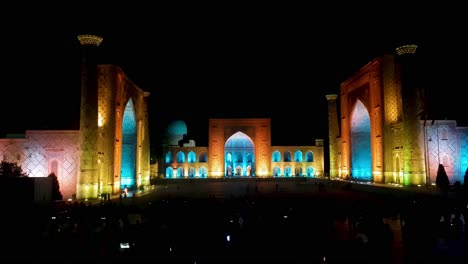 Samarkand-Uzbekistan,-Registan-Square-at-Night,-Colorful-Lights-on-Ancient-Buildings,-Madrasah-and-People