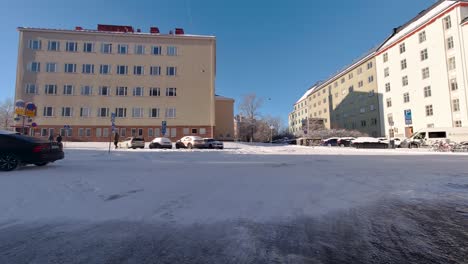 Helsinkis-Schneebedeckte-Straßen-Bieten-Eine-Atemberaubende-Kulisse,-Während-Autos-Anmutig-An-Den-Bezaubernden-Gebäuden-Der-Stadt-Vorbeifahren-Und-Ein-Faszinierendes-Winterbild-Schaffen