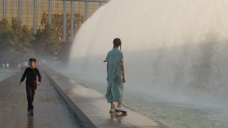 Menschen,-Die-Unter-Dem-Brunnen-Auf-Dem-Unabhängigkeitsplatz-In-Taschkent,-Der-Hauptstadt-Usbekistans,-Spazieren