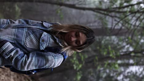 attractive-latina-in-a-checkered-blue-flannel-with-a-blue-backpack-hiking-and-taking-in-the-foggy-nature-environment-VERTICAL-EDITORIAL-4k