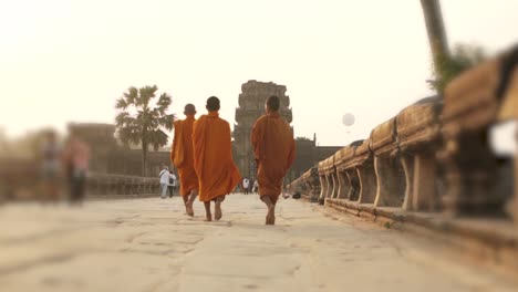 Buddhist-Monks-walking-away-from-the-Ancient-Temple-of-Angkor-Wat---Siem-Reap,-Cambodia
