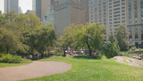 Central-park-static-serene-scene-of-walkway-and-grass-patch-on-hillside,-skyline-behind
