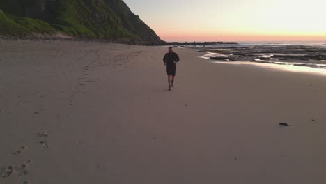 Hombre-Corriendo-Entrenando-En-La-Playa-Al-Amanecer