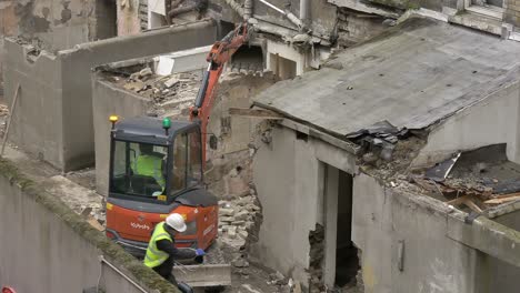 Excavators-rips-apart-knocks-and-pulls-brick-wall-down-from-old-building-in-decrepit-urban-area