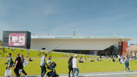 Stedelijk-Museum,-People-Enjoying-Leisure-Time-on-the-Grass,-and-Passersby-on-a-Sunny-Day