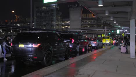 Pan-Left-Shot-View-Of-Parked-Cars-Outside-JFK-Pick-Up-Location-At-Night