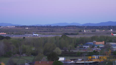 Flugzeug-Startet-Bei-Sonnenaufgang-Mit-Bergen-Im-Hintergrund