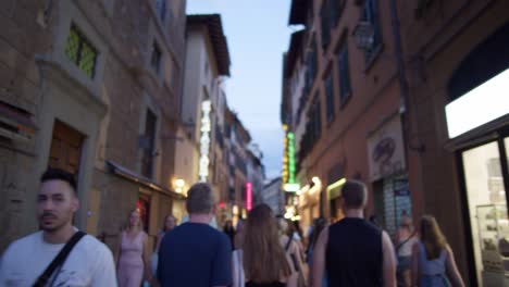 Walking-Down-Busy-Street-in-Florence-Italy-with-Tourists-Shops-Restaurants-During-Evening