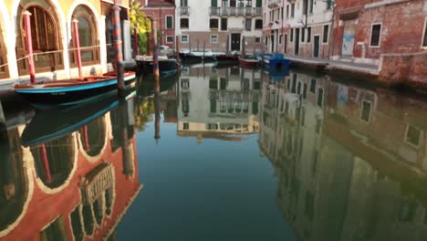 Venezianische-Gebäude,-Die-Sich-Im-Wasser-In-Einem-Leeren-Kanal-In-Venedig,-Italien,-Spiegeln