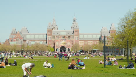Relajación-En-El-Corazón-De-Amsterdam:-Gente-Disfrutando-De-Momentos-Tranquilos-Frente-Al-Rijksmuseum,-Monumento-Histórico
