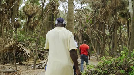 Afrikanischer-Reiseführer,-Der-Mit-Einer-Gruppe-Touristen-In-Gambia-Durch-Den-Affenpark-Spaziert
