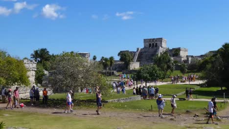Turistas-Que-Visitan-Las-Ruinas-Mayas-Del-Castillo-En-Un-Día-Soleado-En-El-Sitio-Arqueológico-De-Tulum,-Quintana-Roo,-México