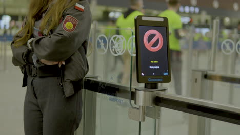 Polish-Female-Security-at-airport-in-Gdansk-checking-area---no-entry-monitor-at-gate,close-up-slow-motion