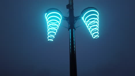 Night-time-wide-shot-tilting-up-from-street-level-to-a-glowing-neon-streetlight