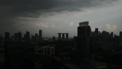 Puesta-De-Sol-Cayendo-Sobre-El-Horizonte-De-Singapur-Con-Nubes-Amenazadoras-Formándose-Hacia-La-Oscuridad