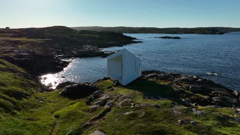 Squish-Studio-Outside-Near-Tilting-with-its-Architectural-Modern-Design-Saunders-Architecture,-Isolated-on-a-Hilltop-of-Rocky-Coastline-from-an-Aerial-Orbital-Drone-with-Scenic-Surroundings