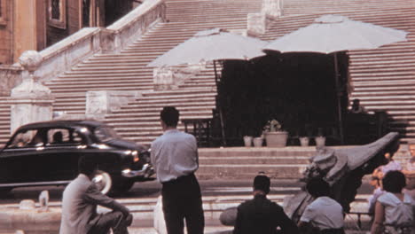 Personas-Reunidas-Alrededor-De-Fontana-Della-Barcaccia-En-Piazza-Di-Spagna-En-Roma-1960