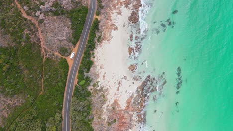 Top-down-drone-view-of-van-parked-on-the-side-of-scenic-winding-road