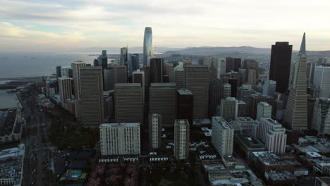 Drone-orbiting-the-city-center-of-San-Francisco,-gloomy-evening-in-California,-USA