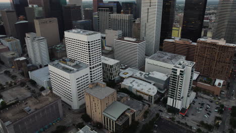 Aerial-view-tilting-toward-the-GreenStreet-complex,-vibrant-evening-in-Houston