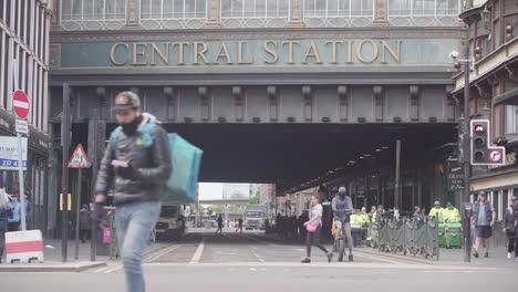 View-of-Central-train-Station-in-Glasgow-as-people-walk-past,-locked-off