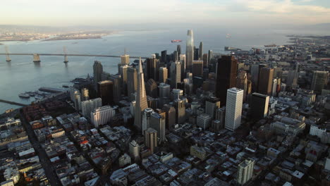 Aerial-view-tilting-away-from-downtown-San-Francisco,-golden-hour-in-CA,-USA