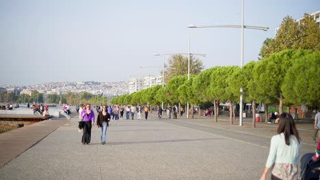 Stadtleben-Am-Meer,-Menschen-Zu-Fuß,-Kinderwagen,-Elektrofahrräder,-Thessaloniki,-Strandpromenade,-Sonniger-Sommertag