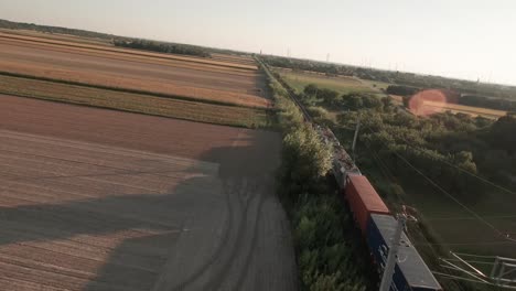 A-cinematic-drone-footage-of-a-train-traversing-a-vast-cornfield,-bathed-in-the-warm-hues-of-an-autumn-evening