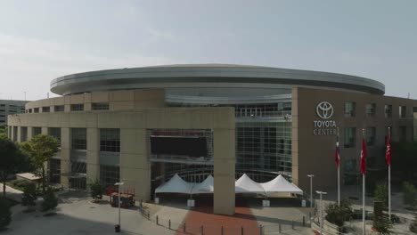 Aerial-drone-view-of-the-main-entrance-to-the-Toyota-Center,-home-of-the-Houston-Rockets,-in-downtown-Houston-Texas