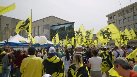 Supporters-of-Flemish-far-right-party-Vlaams-Belang-waving-with-Flags-of-Flanders-and-cheering-during-protest-rally-in-Brussels,-Belgium