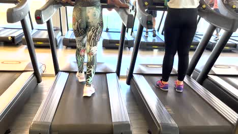 Fit-woman-engages-in-an-indoor-exercise-routine-on-a-treadmill-at-the-gym,-accompanied-by-relaxing-music,-creating-a-soothing-and-invigorating-atmosphere