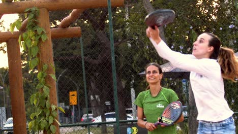 Girl-team-hitting-ball-with-racket-playing-beach-tennis