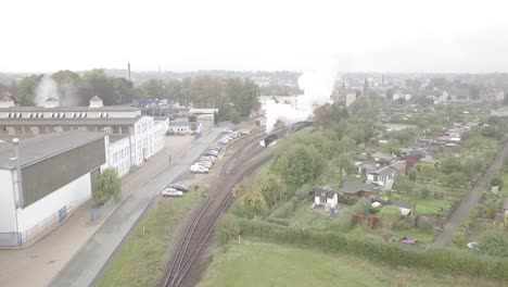 Drone-shot-of-an-old-steam-locomotive-leaving-a-station