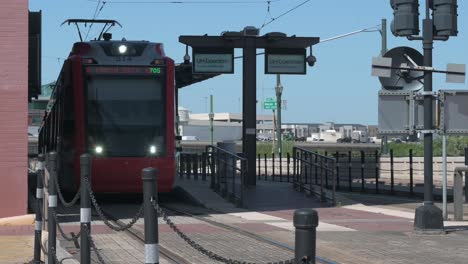 Shot-of-a-Houston-Metro-train-panning-left-to-right-as-it-passes-by-at-the-UHD-Station-on-Main-Street-in-Houston-Texas