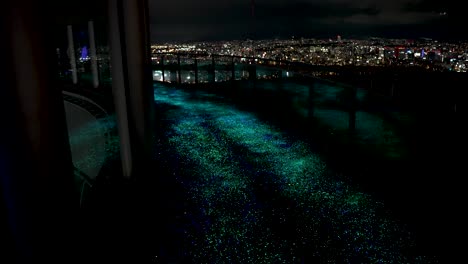 Camino-LED-Iluminado-En-La-Parte-Superior-Del-Edificio-Con-Vistas-Al-Horizonte-De-La-Ciudad-De-Osaka-Por-La-Noche